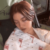 a woman is sleeping on a giraffe blanket