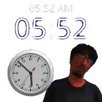 a man stands in front of a wall clock that says 5:52 am