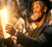 a man in a suit holds a piece of paper in his hand