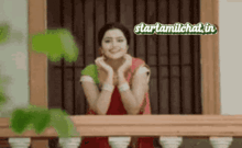 a woman sitting on a balcony with a startamilchat.in logo on the bottom
