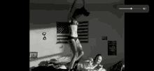 a black and white photo of a woman in lingerie jumping on a bed