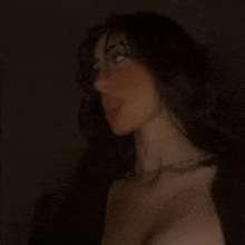 a woman is standing in the dark with her eyes closed .