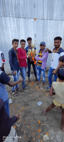 a group of young men are posing for a picture with a trophy