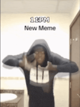 a man in a hoodie is standing in front of a wall that says 11 pm new meme