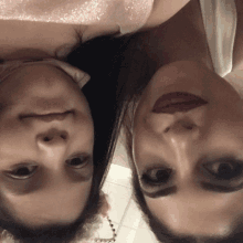 two women are looking at the camera with their faces turned upside down