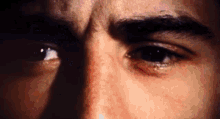 a close up of a man 's eyes with a tear running down his cheek