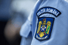 a blue patch on a person 's shirt says politia romana