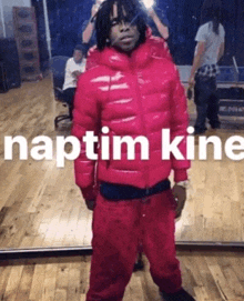 a man in a red jacket is standing in front of a mirror with the words naptim kine on the bottom