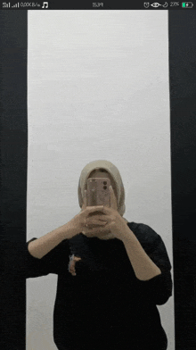 a woman taking a picture of herself in a mirror on her phone