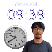 a man with glasses stands in front of a clock that says 9:39 am