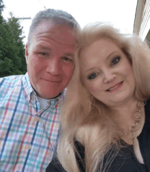 a man in a plaid shirt and a woman in a black shirt are posing for a picture