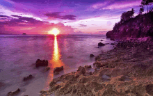 a sunset over a body of water with a purple sky