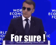 a man wearing sunglasses is giving a speech at the world economic forum annual meeting