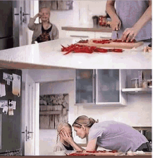 a woman is putting her hand on a child 's face while a man cuts peppers on a cutting board