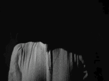 a black and white photo of a person 's face in the dark