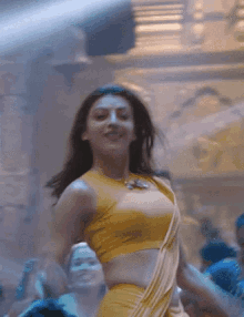 a woman in a yellow top and white skirt is dancing in a crowd .