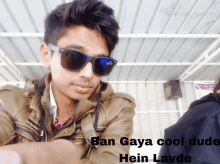 a young man wearing sunglasses and a brown jacket with ban gaya cool dude hein layde written on the bottom