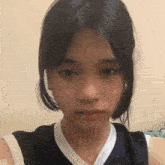 a girl with long black hair is taking a selfie with her phone .