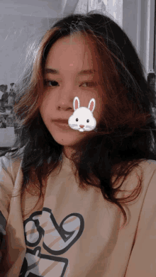 a girl with a bunny sticker on her face takes a selfie