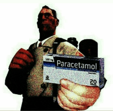 a man is holding a box of paracetamol