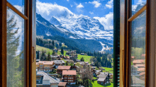 a view of a mountain range from a window with a village in the foreground