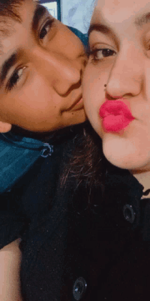 a woman with pink lips kisses a man on the cheek