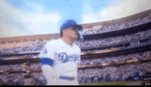 a dodgers player is standing in front of a crowd in a stadium