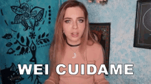 a woman says " wei cuidame " in front of a tapestry