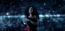 a woman in a red and black dress is standing in front of a starry night sky