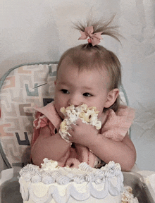 a baby in a high chair eating a cake