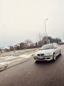 a silver bmw is driving down a snowy road with a license plate that says sdcw 643