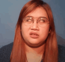 a woman wearing glasses is making a funny face and making a funny face .