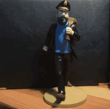 a figurine of a man with a beard is standing on a wooden surface