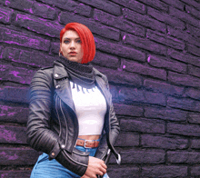 a woman with red hair wearing a black leather jacket stands in front of a purple brick wall