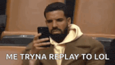a man is sitting in a stadium looking at his cell phone .