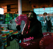 a man is riding a pink flamingo float with the word himbo on it