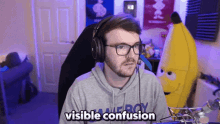 a man wearing headphones says visible confusion in front of a banana