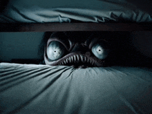 a scary monster is peeking out from under a bed