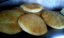 a bunch of bread with sesame seeds on them on a table