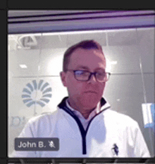 a man wearing glasses and a white jacket with the name john b. on the bottom