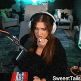 a woman wearing headphones is sitting in front of a microphone with a book titled creative curses