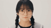 a close up of a girl wearing glasses with pigtails