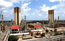 an aerial view of a large industrial plant with a blue sky and clouds