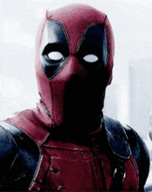 a close up of deadpool 's face with his eyes closed .