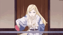 a blonde anime girl is holding a ping pong paddle in her hand .