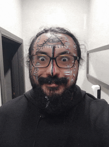 a man with glasses and a beard has his face painted in various colors