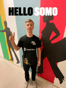 a man wearing a black shirt that says layer zero giving a peace sign