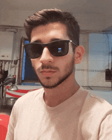 a man wearing sunglasses looks at the camera