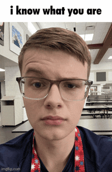 a young man wearing glasses and a lanyard that says ' i know what you are '