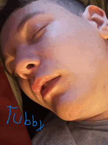 a close up of a person 's face with the name tubby written on the bottom